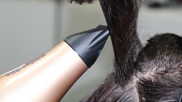 家庭用ヘアドライヤーで髪を乾かす様子。工業用熱風機との熱量比較のイメージ。