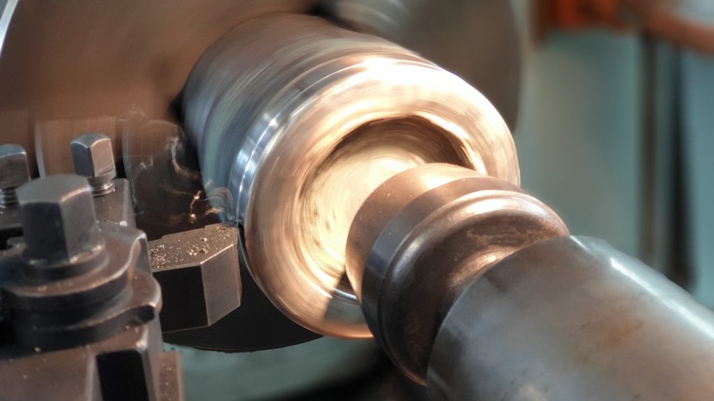 旋盤でシャフトを精密加工する様子とはめあい公差のイメージ