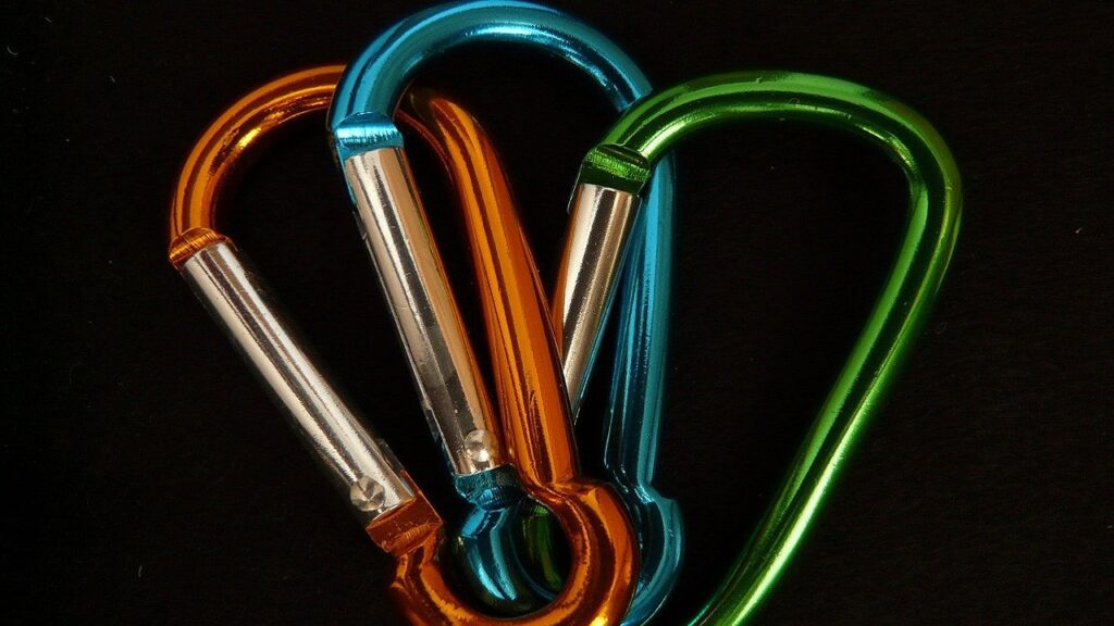 オレンジ、青、緑に着色されたアルミニウム製カラビナ。アルマイトの微細な孔に染料を吸着させたカラーアルマイトの美しさと質感。