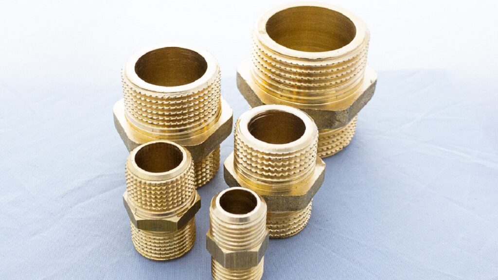 黄金色の光沢がある黄銅（真鍮）製のニップルや継手など、様々なサイズの配管部品が並んでいる様子