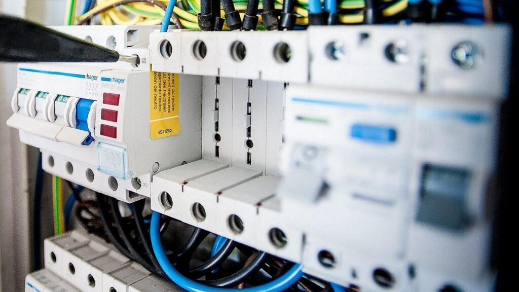 電気設備のブレーカーボックスで絶縁不良を点検するエンジニアの手元。JIS規格に基づいた漏電・感電対策、アースと漏電遮断器の仕組みを解説する記事のアイキャッチ。