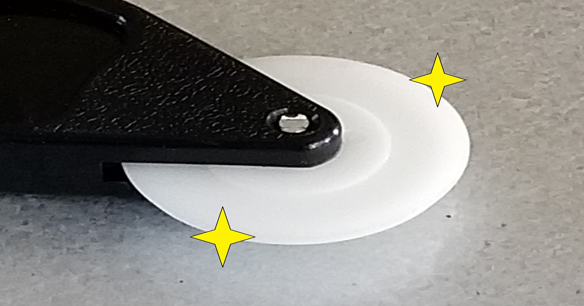 網戸の張り替えに使用する白いディスク状の専用ローラー。