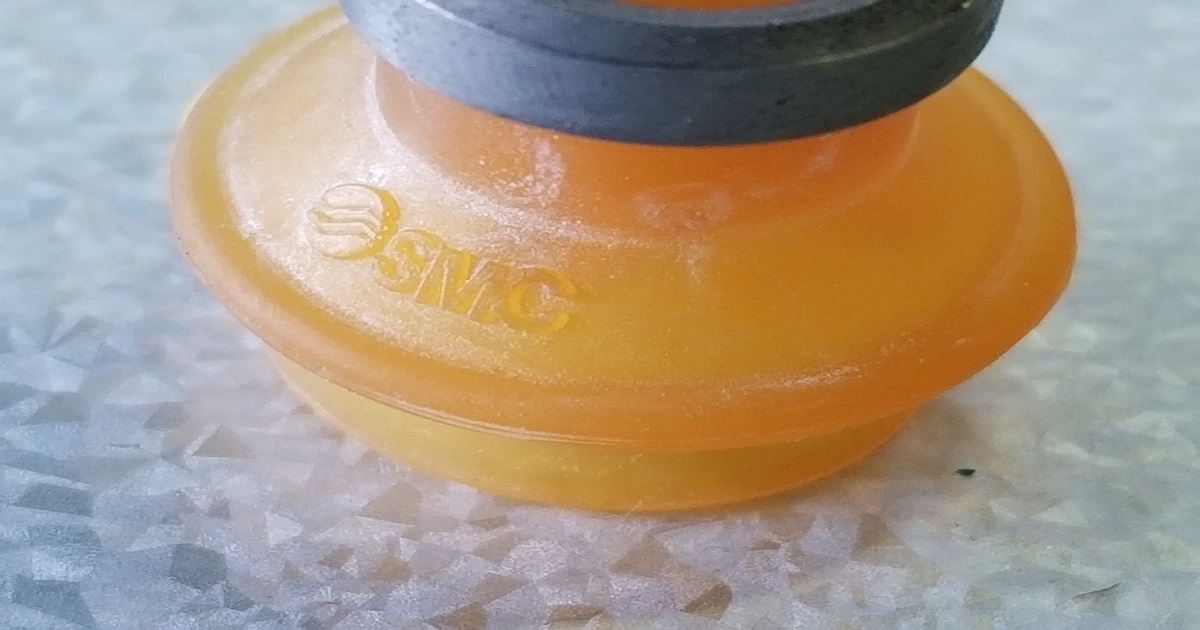 真空吸着パッドが薄物金属シートを保持している様子。搬送トラブルの原因調査における観察記録。